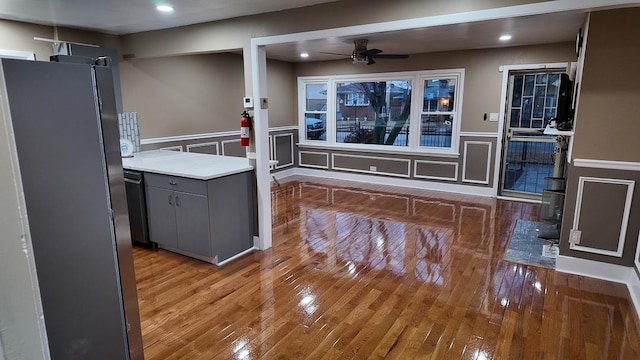 kitchen featuring hardwood / wood-style flooring, a decorative wall, a ceiling fan, and gray cabinetry