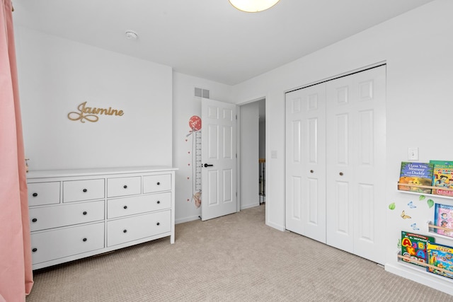 bedroom featuring a closet, light carpet, visible vents, and baseboards