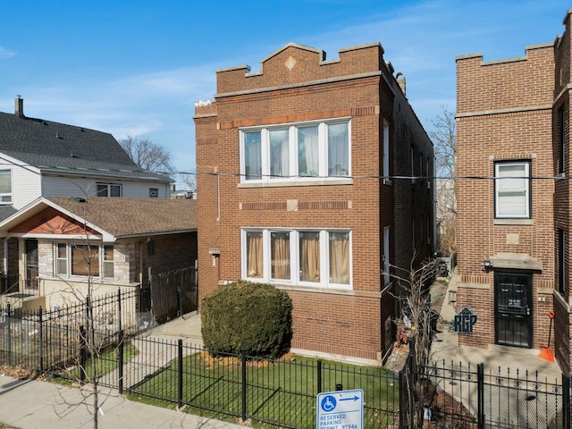 front of property with a fenced front yard and brick siding