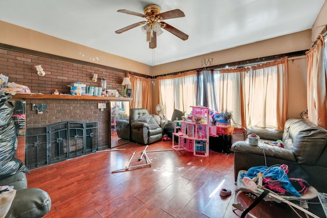 living room with ceiling fan, a fireplace, and wood finished floors