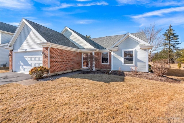 single story home with a front lawn, brick siding, driveway, and an attached garage