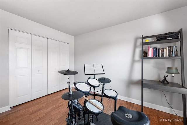 misc room with baseboards and wood finished floors