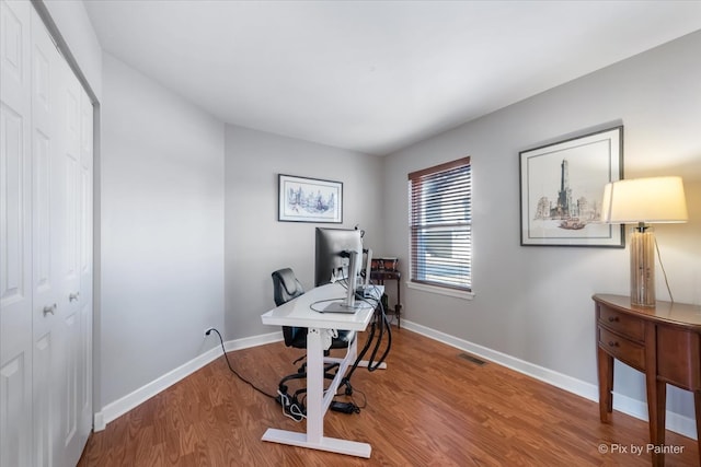 office with visible vents, baseboards, and wood finished floors