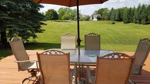 wooden terrace featuring outdoor dining space and a lawn