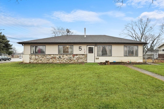 ranch-style home featuring stone siding, a front lawn, and fence