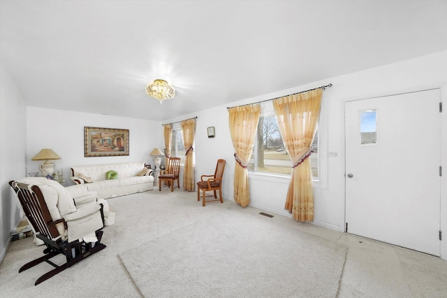 living area with visible vents and carpet floors