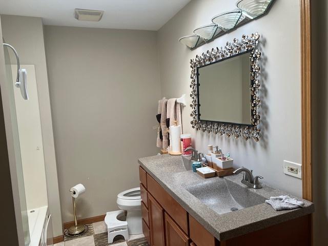 bathroom with visible vents, vanity, toilet, and baseboards