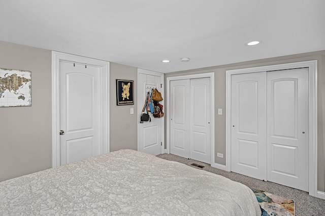 carpeted bedroom with baseboards, multiple closets, and recessed lighting