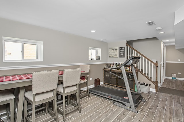 workout room featuring baseboards, visible vents, and wood finish floors