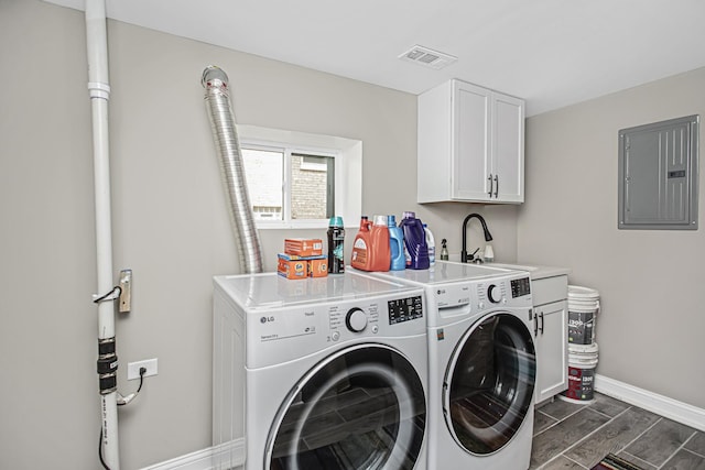 washroom with cabinet space, electric panel, visible vents, wood tiled floor, and washing machine and dryer