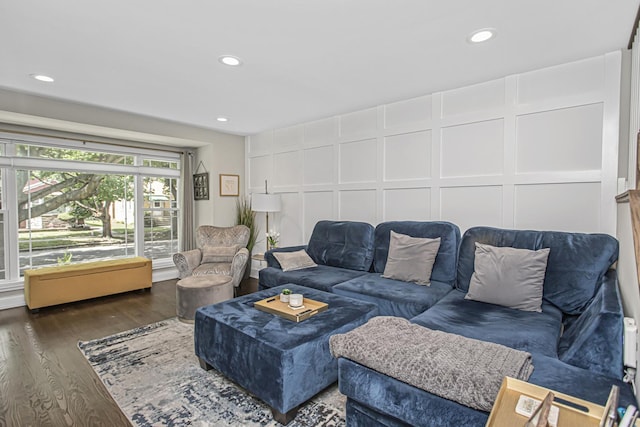 living room featuring recessed lighting, wood finished floors, and a decorative wall