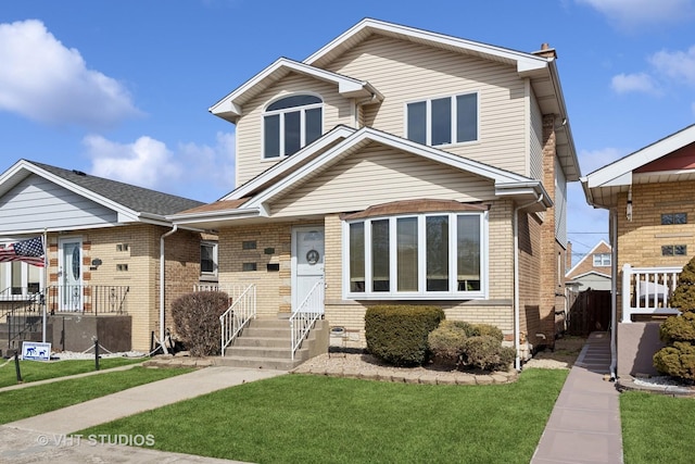 view of front of house featuring a front lawn and brick siding