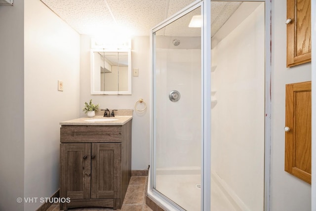full bath featuring a stall shower, vanity, and baseboards