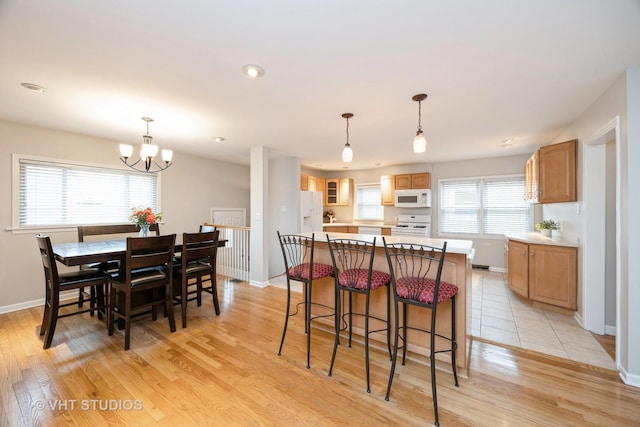 kitchen featuring light wood-style floors, light countertops, white appliances, and a kitchen island