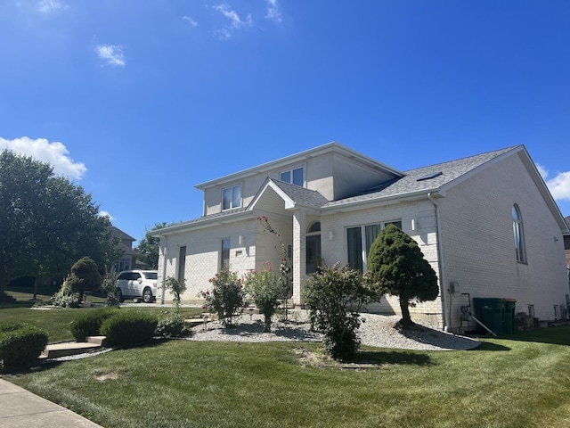 view of front facade with brick siding and a front yard