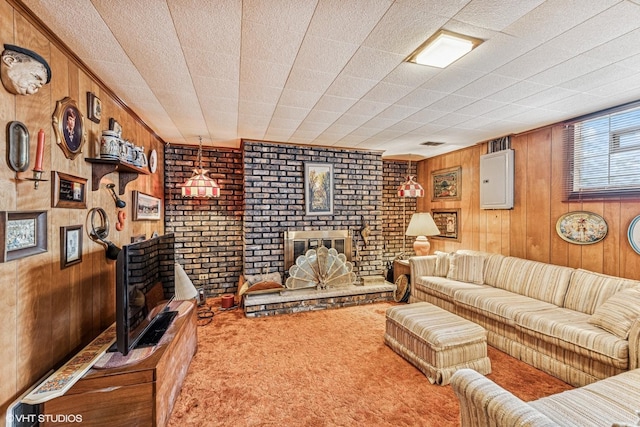 carpeted living room with a brick fireplace and wood walls