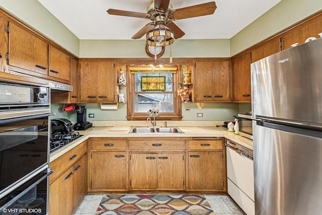 kitchen featuring a sink, light countertops, brown cabinetry, and stainless steel appliances