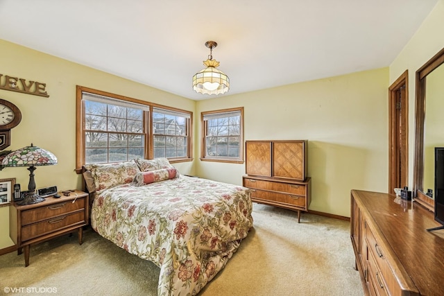 bedroom featuring baseboards and light carpet