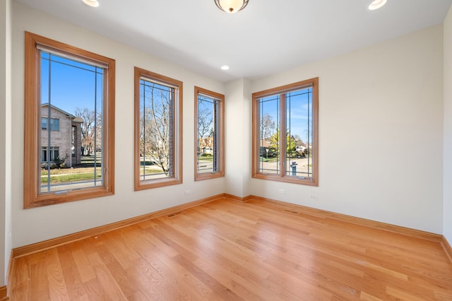 empty room featuring light wood-style floors, recessed lighting, and baseboards