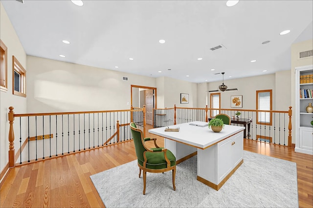 kitchen featuring visible vents, a kitchen island, and light wood-style flooring