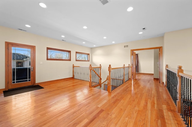 hall with visible vents, light wood-style flooring, an upstairs landing, and recessed lighting