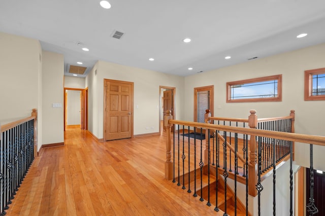 corridor featuring recessed lighting, visible vents, an upstairs landing, light wood-type flooring, and baseboards