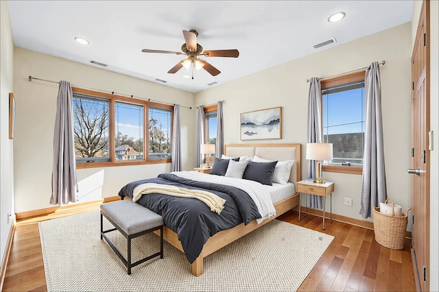 bedroom featuring wood-type flooring, visible vents, baseboards, and recessed lighting