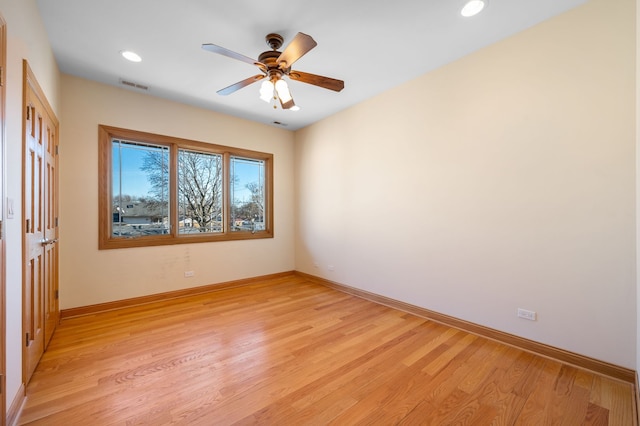 spare room featuring visible vents, light wood-style flooring, and baseboards