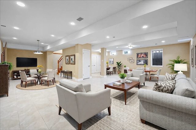 living area with light tile patterned floors, baseboards, visible vents, stairway, and recessed lighting