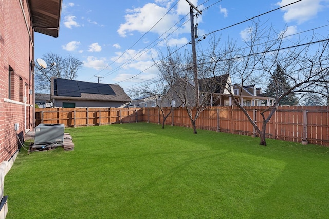 view of yard with central AC and a fenced backyard