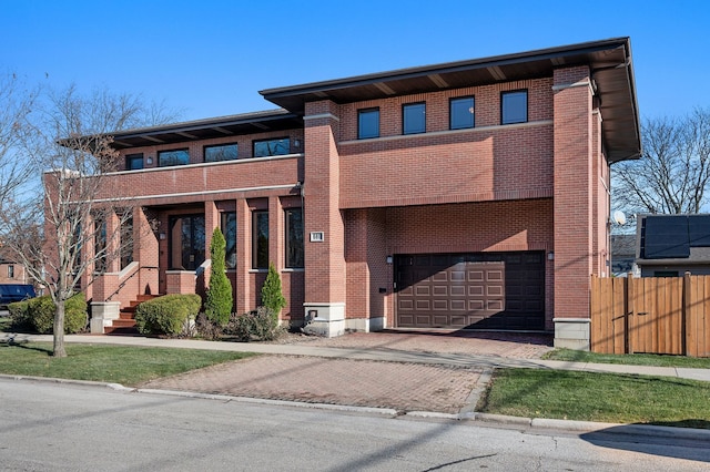 view of front of house with aphalt driveway, brick siding, fence, and an attached garage