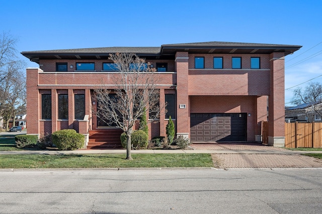 prairie-style house featuring a garage, decorative driveway, and brick siding