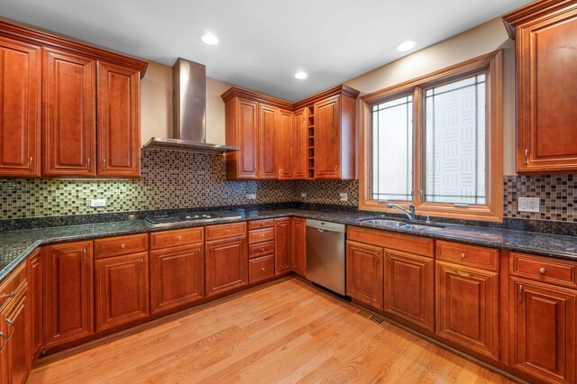 kitchen with cooktop, light wood-style flooring, stainless steel dishwasher, wall chimney range hood, and a sink