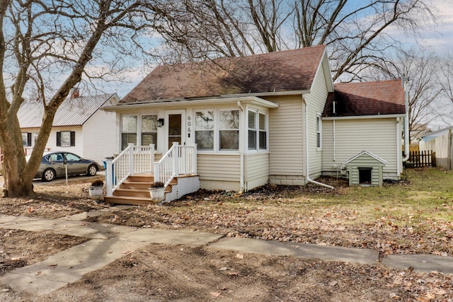 bungalow with fence and roof with shingles