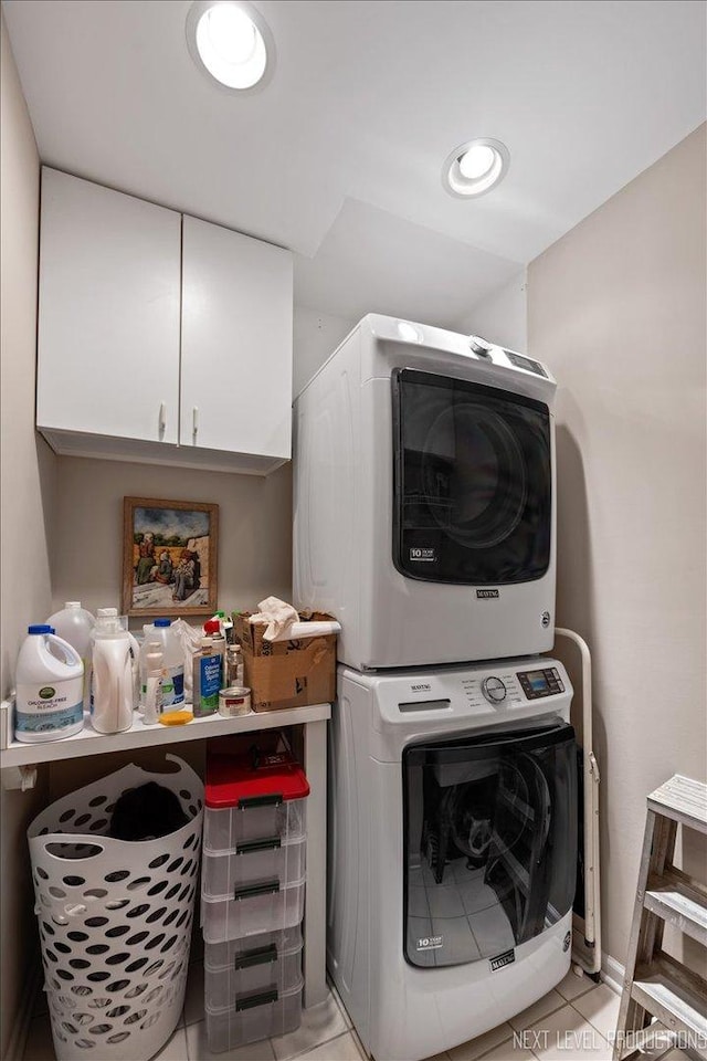 laundry room with stacked washer / drying machine, light tile patterned flooring, cabinet space, and recessed lighting