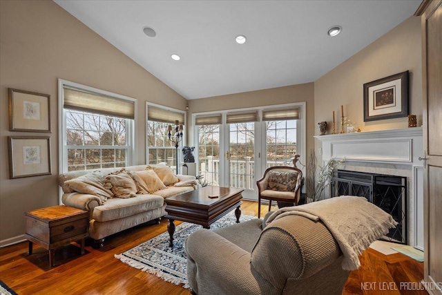 living area featuring lofted ceiling, a fireplace, recessed lighting, and wood finished floors