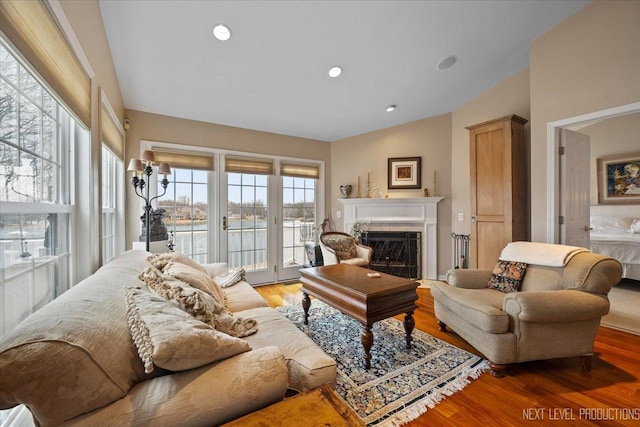 living area with vaulted ceiling, a fireplace, light wood-style flooring, and recessed lighting