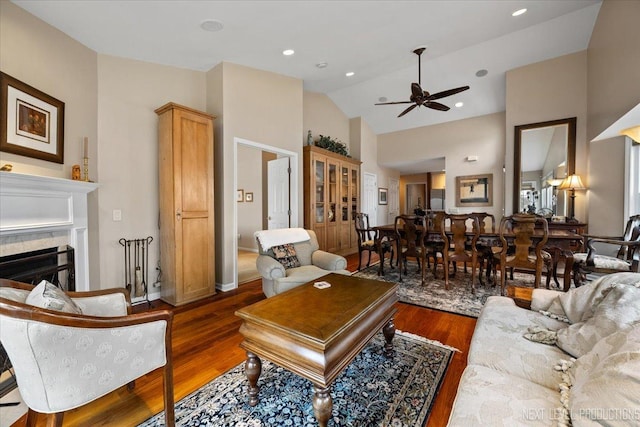 living area featuring a fireplace, recessed lighting, ceiling fan, wood finished floors, and high vaulted ceiling