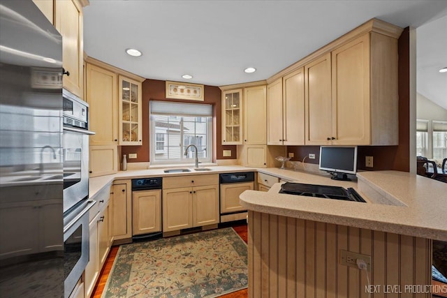 kitchen with oven, light brown cabinets, a peninsula, and dishwashing machine