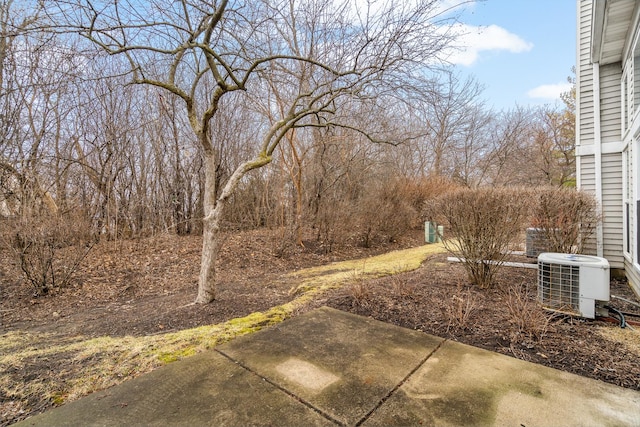 view of yard with central AC and a patio