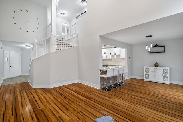 foyer with stairway, a high ceiling, baseboards, and wood finished floors