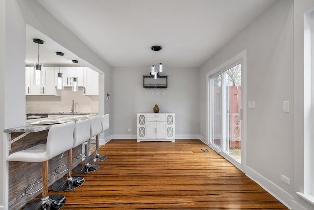 dining space with baseboards and wood finished floors