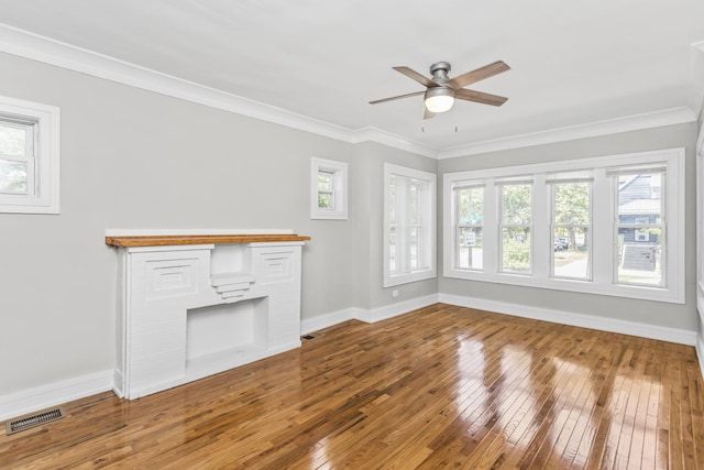 unfurnished living room with ornamental molding, wood-type flooring, a fireplace, and baseboards