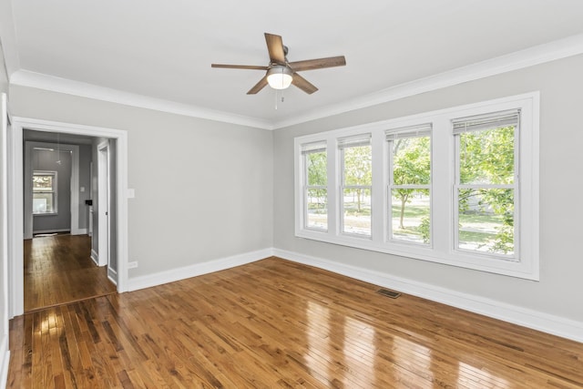 unfurnished room featuring visible vents, crown molding, baseboards, and hardwood / wood-style flooring