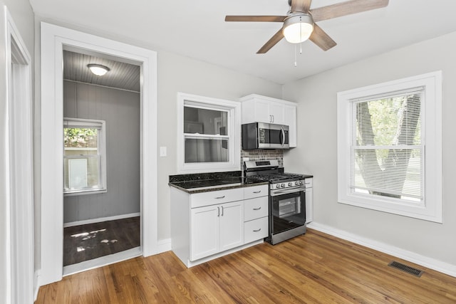 kitchen with stainless steel appliances, a healthy amount of sunlight, visible vents, and white cabinetry