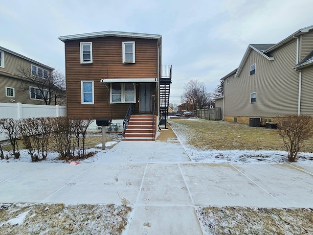 view of front of house with fence and central AC