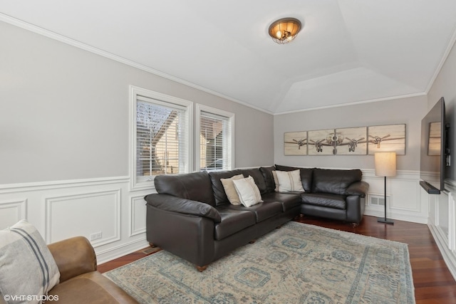 living room featuring visible vents, wainscoting, lofted ceiling, ornamental molding, and dark wood-type flooring