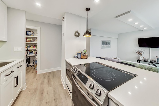 kitchen featuring light countertops, stainless steel electric range oven, and light wood finished floors