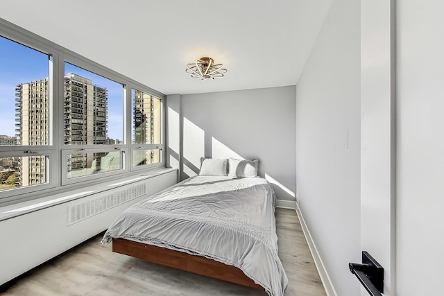 bedroom featuring baseboards and wood finished floors