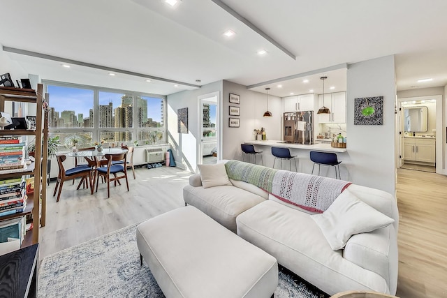 living area with recessed lighting, light wood-type flooring, and a city view